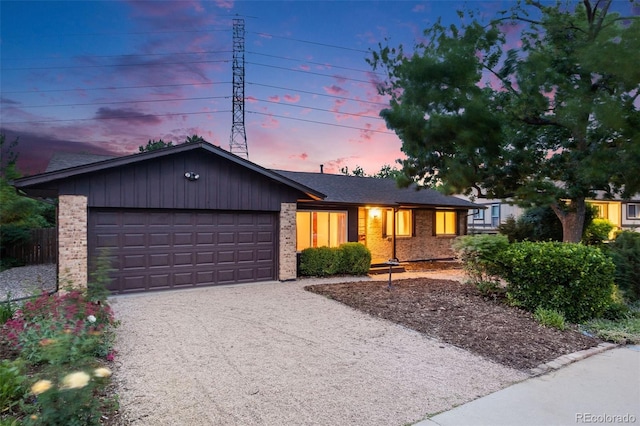 7382 E Bates Dr, Denver, CO 80231 - view of front facade with brick siding, a garage, and driveway