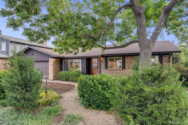 7382 E Bates Dr, Denver, CO 80231 - view of front of home featuring brick siding, a garage, and a shingled roof