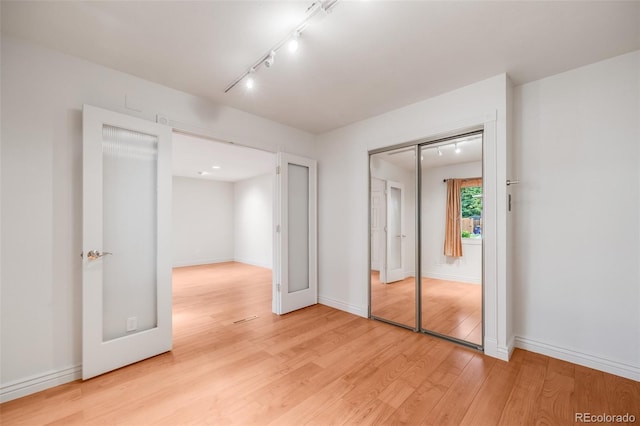 7382 E Bates Dr, Denver, CO 80231 - unfurnished bedroom featuring light wood finished floors, track lighting, and a closet