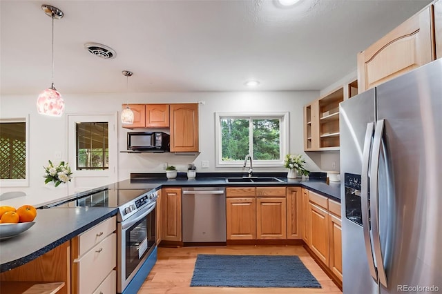 7382 E Bates Dr, Denver, CO 80231 - kitchen with appliances with stainless steel finishes, dark countertops, light wood-style flooring, hanging light fixtures, and recessed lighting