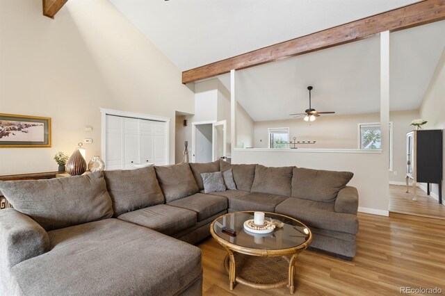 living room with light wood-type flooring, beam ceiling, high vaulted ceiling, and ceiling fan