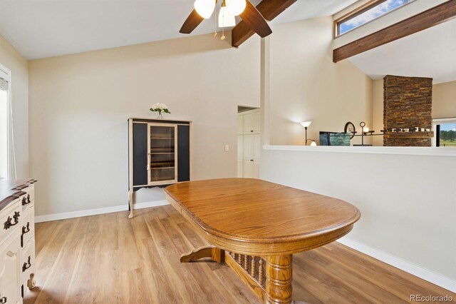 dining room with a wealth of natural light, beam ceiling, ceiling fan, and light wood-type flooring