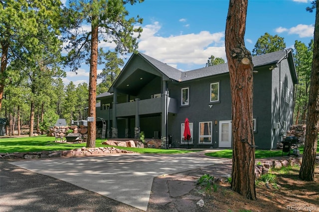 exterior space featuring a balcony and a front lawn