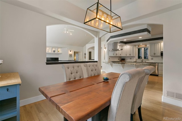 dining room with ceiling fan, sink, and light hardwood / wood-style floors