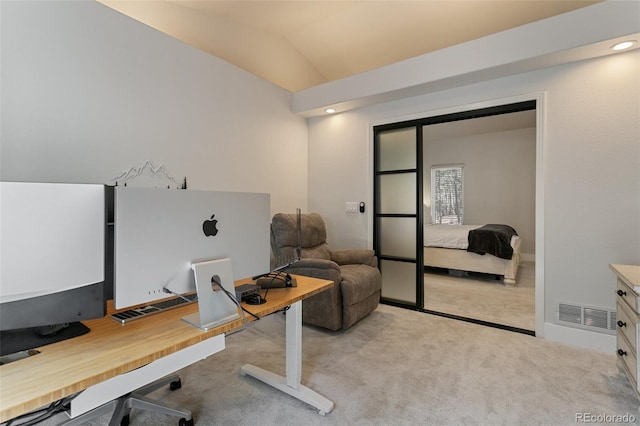 home office with lofted ceiling and light colored carpet