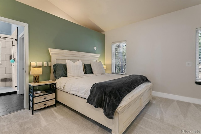 bedroom featuring carpet flooring, connected bathroom, and vaulted ceiling