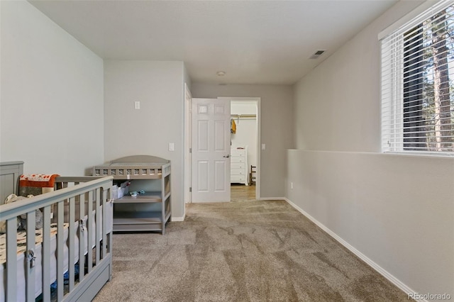 bedroom featuring a nursery area and carpet floors