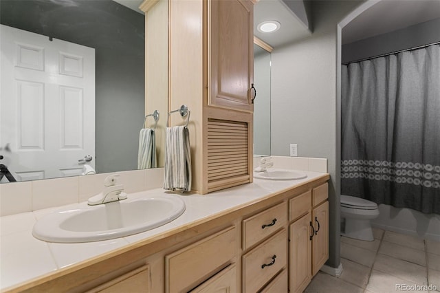 bathroom featuring tile flooring, double vanity, and toilet