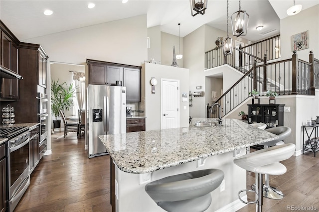 kitchen with sink, dark hardwood / wood-style floors, appliances with stainless steel finishes, and a notable chandelier