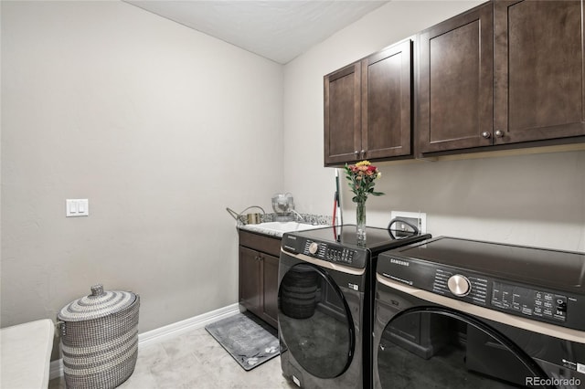 laundry room with cabinets, washing machine and dryer, and sink