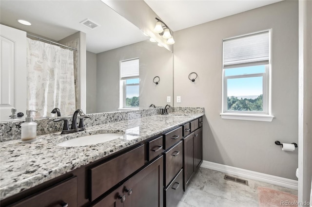 bathroom featuring tile patterned floors, toilet, a wealth of natural light, and vanity