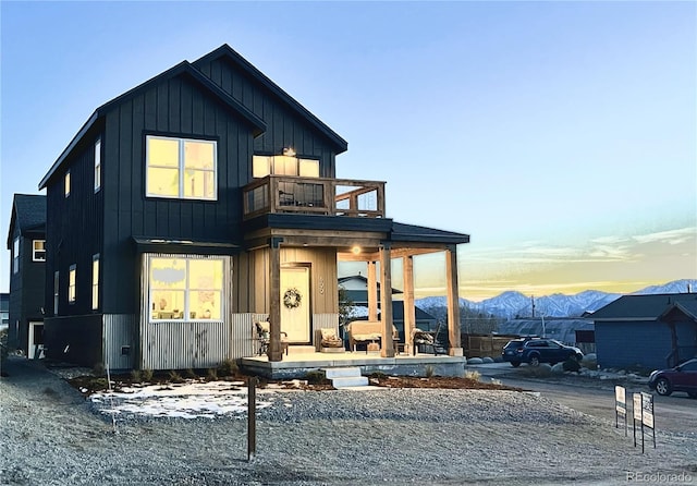 view of front of house featuring a balcony, a mountain view, and covered porch