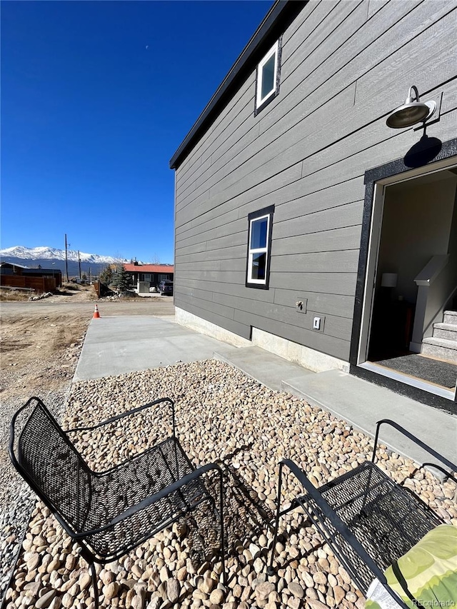 view of side of home featuring a mountain view and a patio area