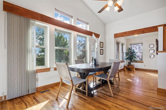 dining space with ceiling fan, light hardwood / wood-style flooring, and vaulted ceiling