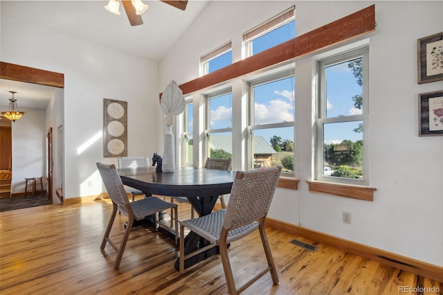 dining area with ceiling fan, plenty of natural light, vaulted ceiling, and wood-type flooring