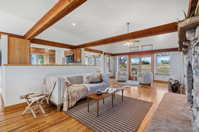 living room with lofted ceiling with beams, a fireplace, ceiling fan, and light hardwood / wood-style floors