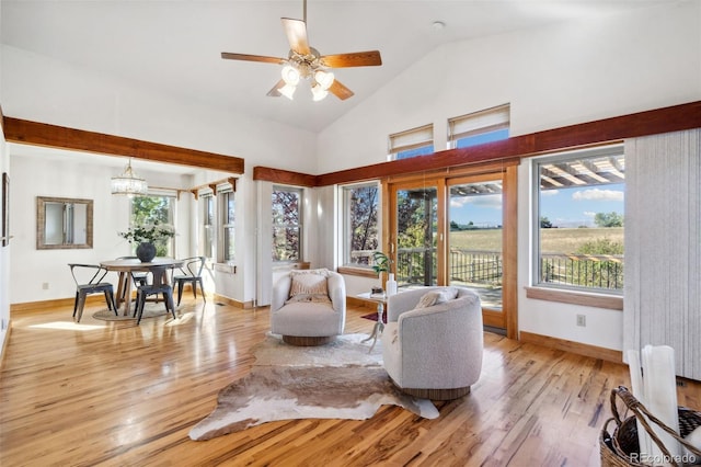 living room with light hardwood / wood-style floors, high vaulted ceiling, and ceiling fan