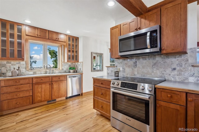 kitchen with stainless steel appliances, tasteful backsplash, and light hardwood / wood-style flooring