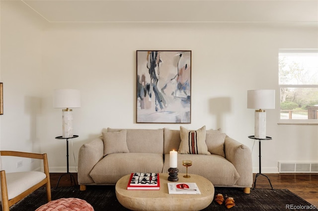 living area featuring baseboards, wood finished floors, and visible vents