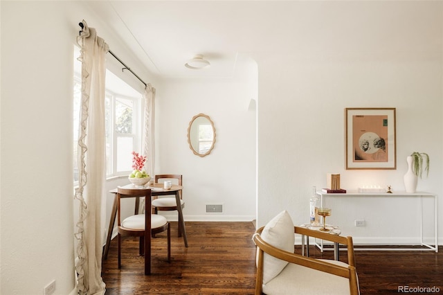 sitting room with visible vents, arched walkways, baseboards, and wood finished floors