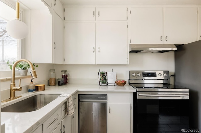 kitchen featuring light countertops, a sink, under cabinet range hood, and stainless steel appliances