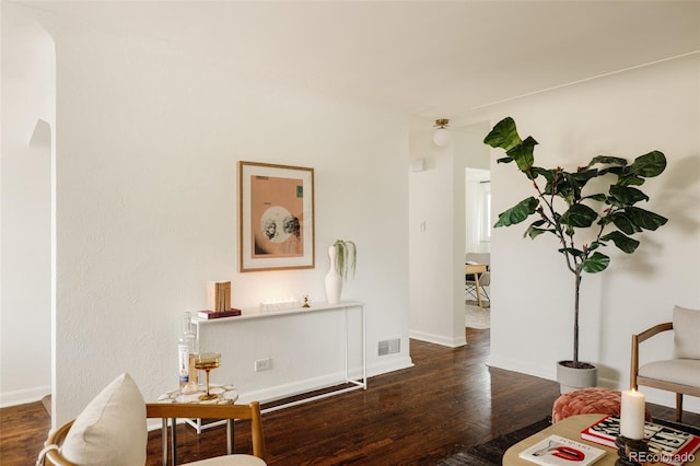 living area with visible vents, baseboards, and wood finished floors
