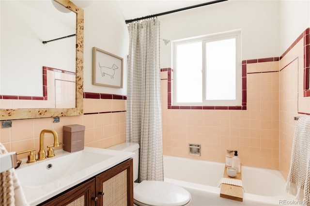full bath featuring tile walls, shower / bath combo with shower curtain, vanity, and toilet