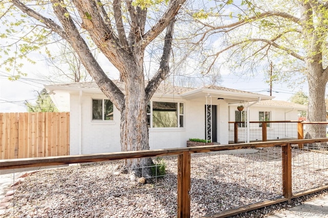 view of front of home with a shingled roof, fence private yard, and stucco siding