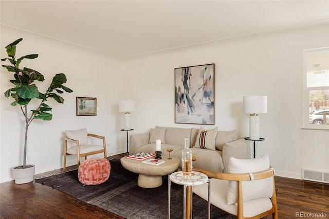 living area with visible vents, baseboards, and wood finished floors