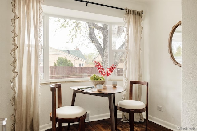 dining room with baseboards, a textured wall, and dark wood-style floors
