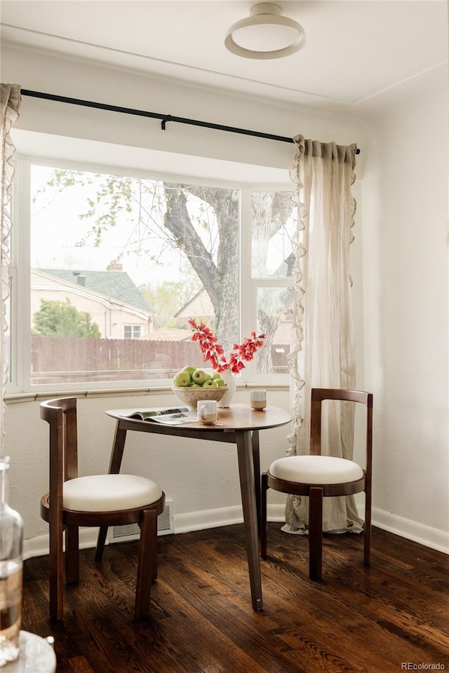 dining room featuring a healthy amount of sunlight, baseboards, and wood finished floors
