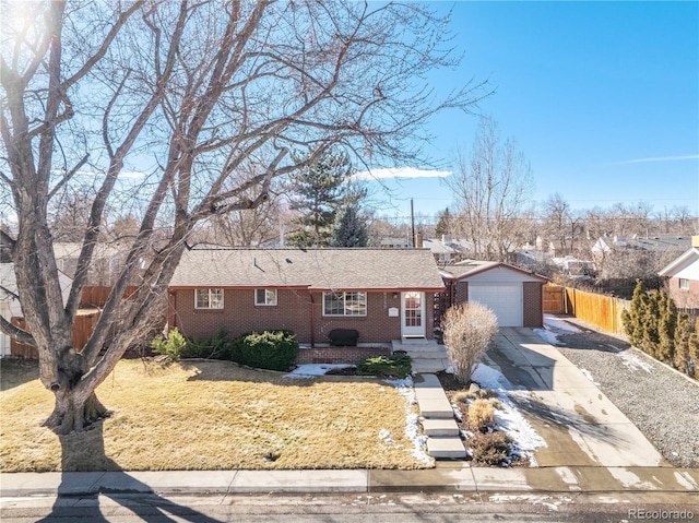 single story home with a garage, driveway, brick siding, and fence