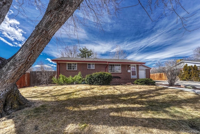 view of front of home with an attached garage, a front yard, and fence