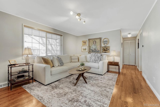 living room with visible vents, crown molding, baseboards, and wood finished floors