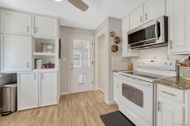 kitchen with white cabinets, electric stove, light wood-type flooring, dark stone counters, and stainless steel microwave