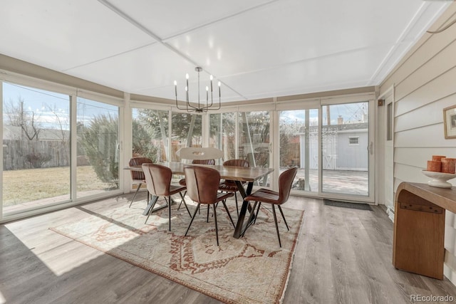 sunroom / solarium with a chandelier