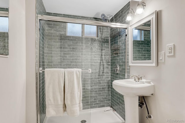 bathroom featuring a stall shower and a sink