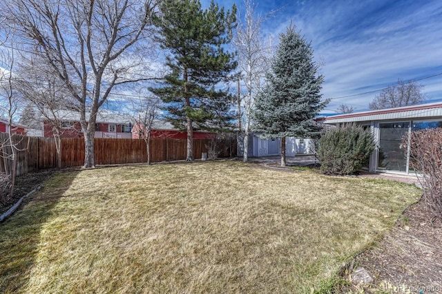 view of yard with a fenced backyard and an outbuilding