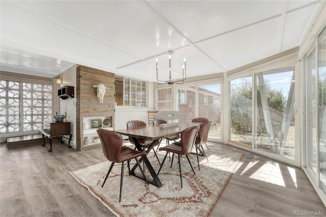 sunroom / solarium with an inviting chandelier and a fireplace