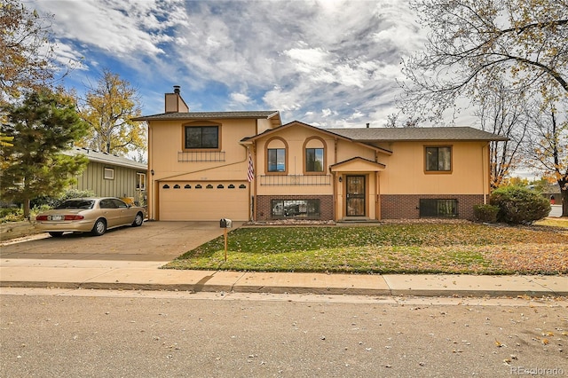 bi-level home featuring a front yard and a garage