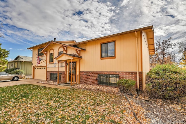 split foyer home with a garage and a front lawn