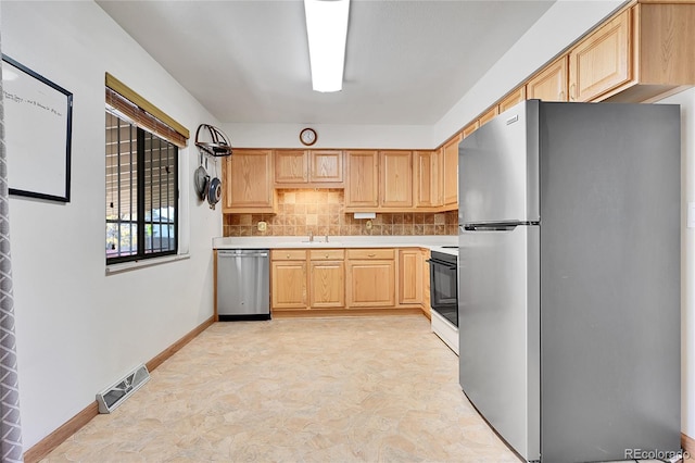 kitchen with appliances with stainless steel finishes, tasteful backsplash, light brown cabinetry, and sink