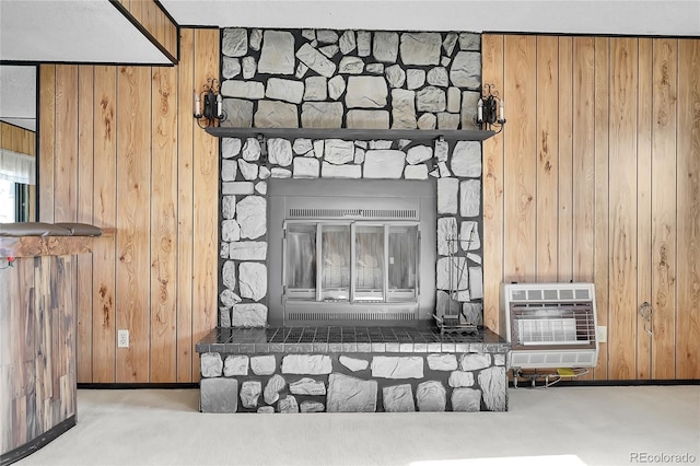 details featuring carpet, wood walls, a fireplace, and heating unit