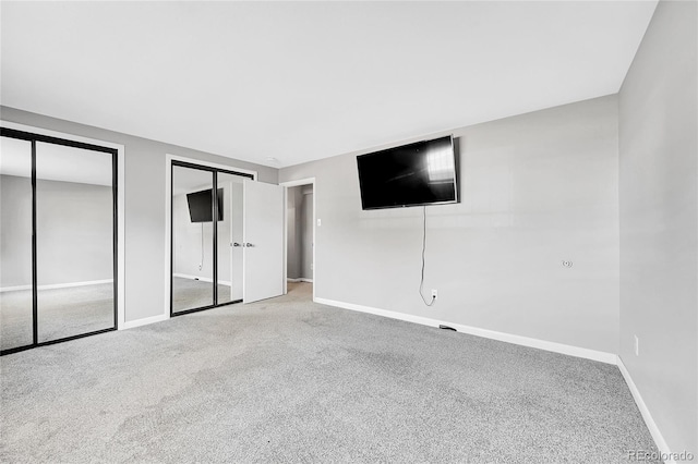 unfurnished bedroom with carpet and two closets