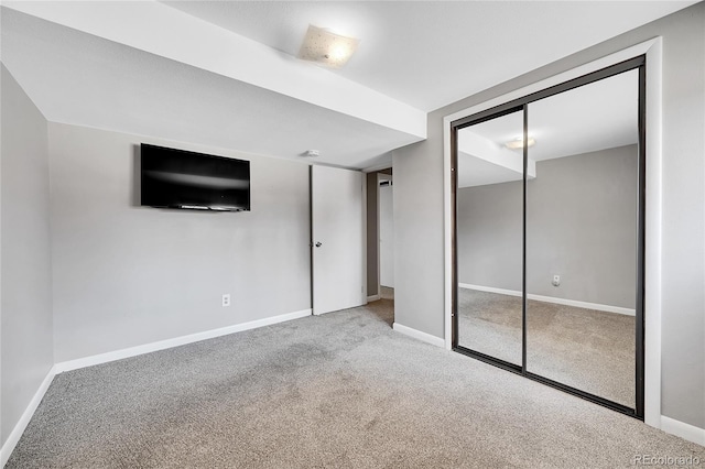 unfurnished bedroom with light carpet and a closet