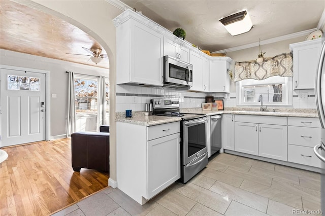 kitchen featuring stainless steel appliances, white cabinetry, sink, and backsplash