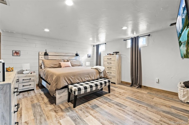 bedroom with wooden walls and light wood-type flooring