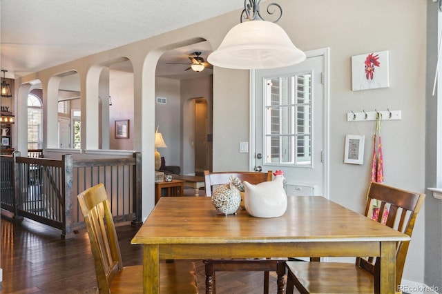 dining space with ceiling fan and dark hardwood / wood-style flooring