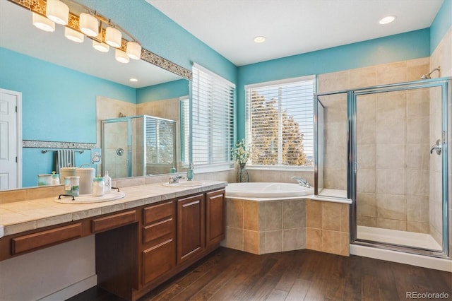 bathroom featuring hardwood / wood-style flooring, vanity, and separate shower and tub