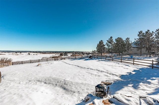 snowy yard with a rural view